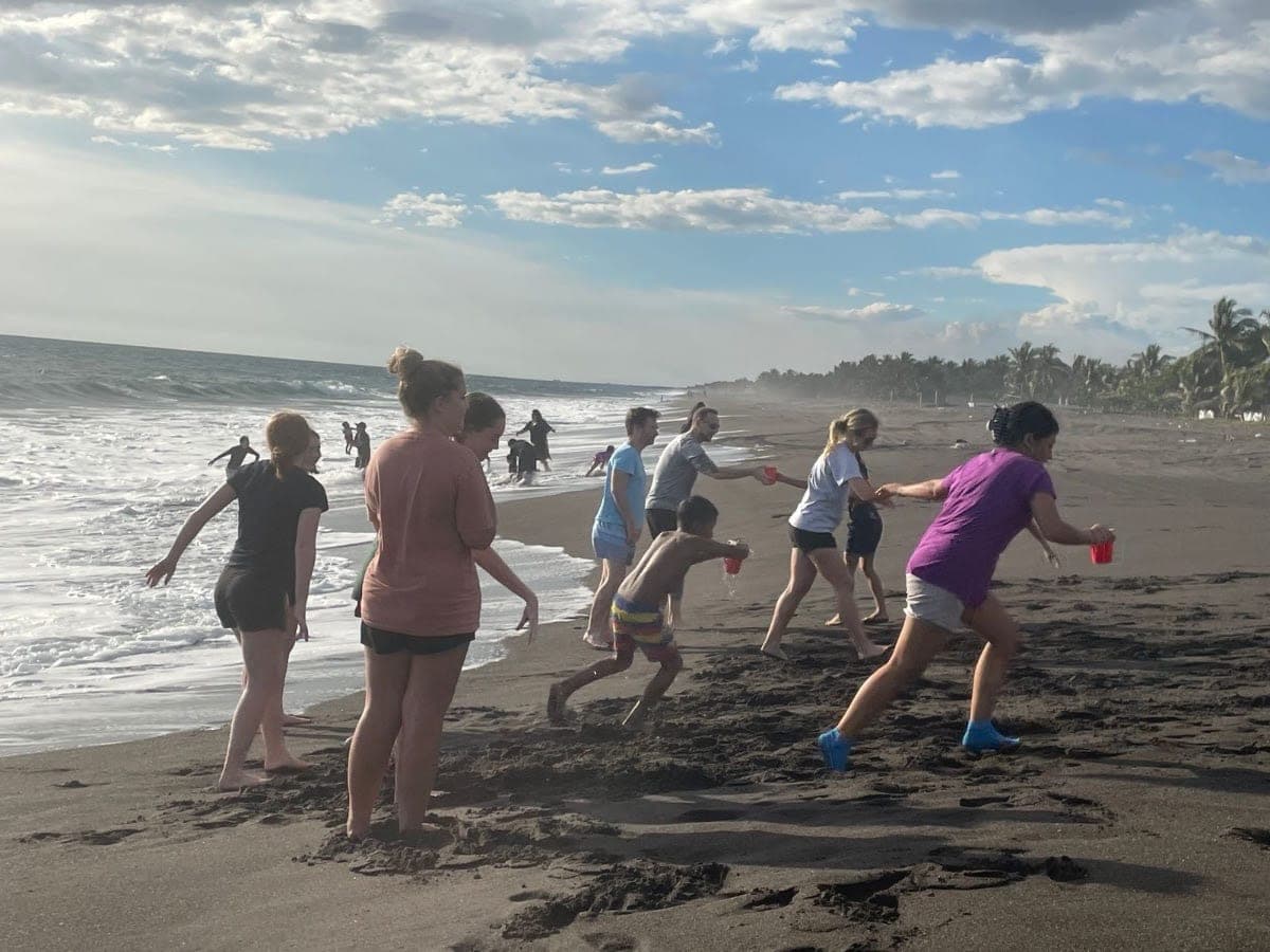 People playing on the black-sand beach at Monterrico