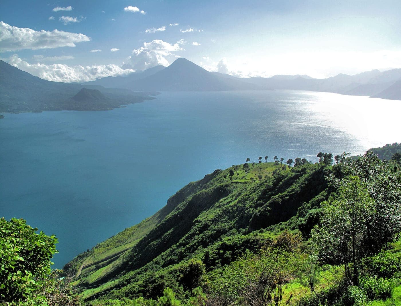 Lake Atitlán with green hills and volcanoes in the distance